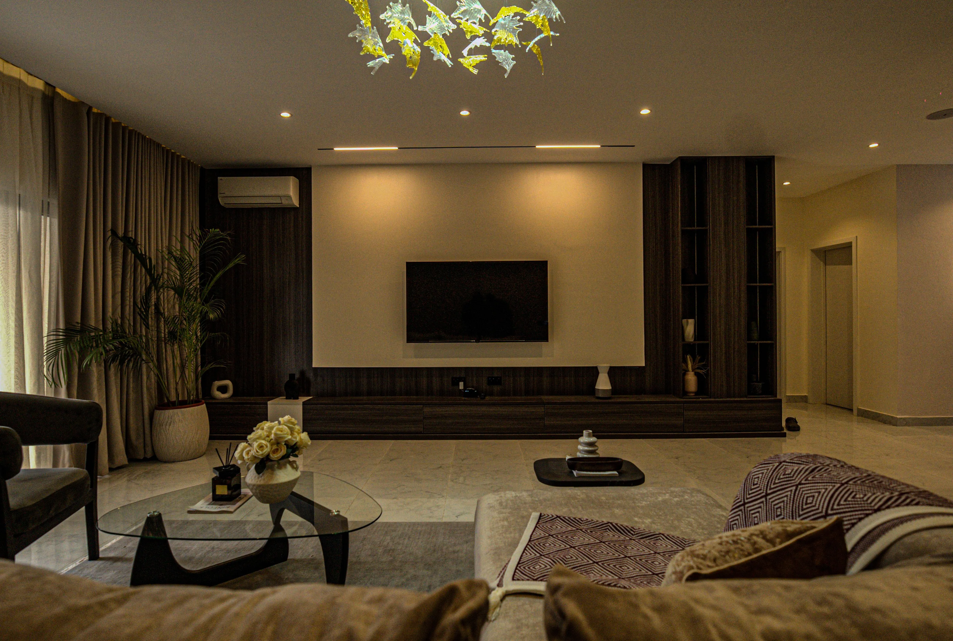 Living-room media wall, long low console and layered ceiling lighting